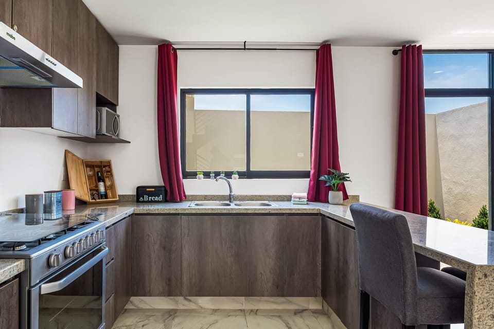 Prepare meals with ease in the contemporary kitchen featuring stainless steel appliances, ample counter space, and natural light.