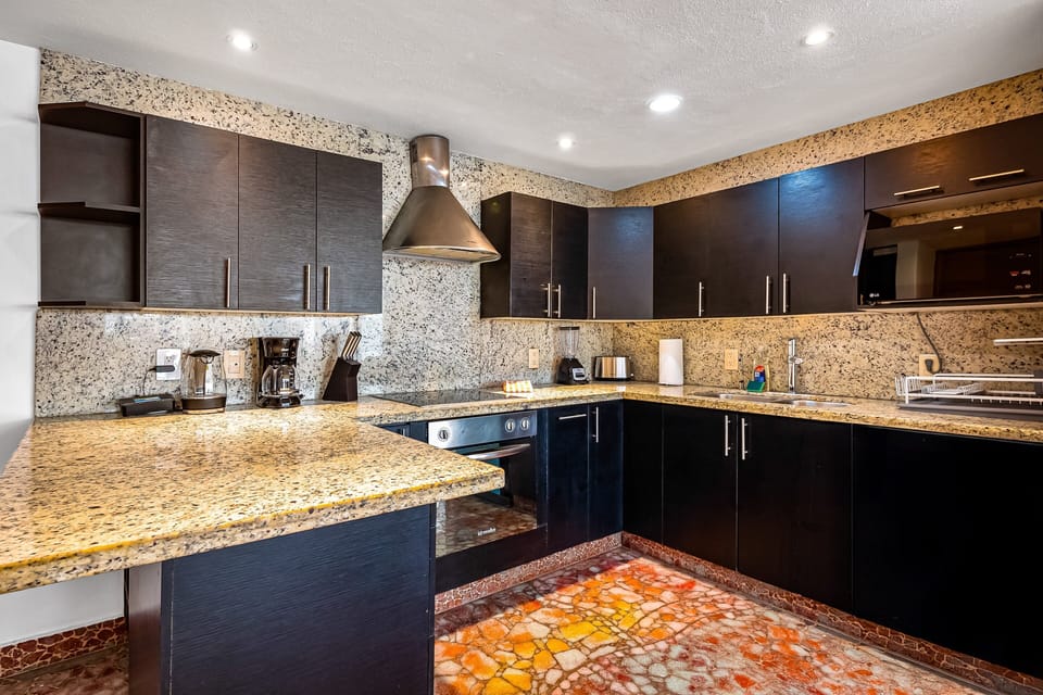 Cook with ease in the modern kitchen featuring granite countertops, stainless steel appliances, and everything needed for your stay.