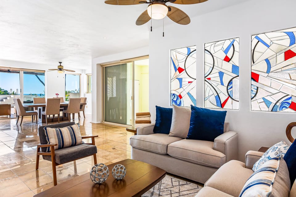 Comfortable open-concept living area with stylish seating, natural light, Smart TV, and direct access to the terrace.