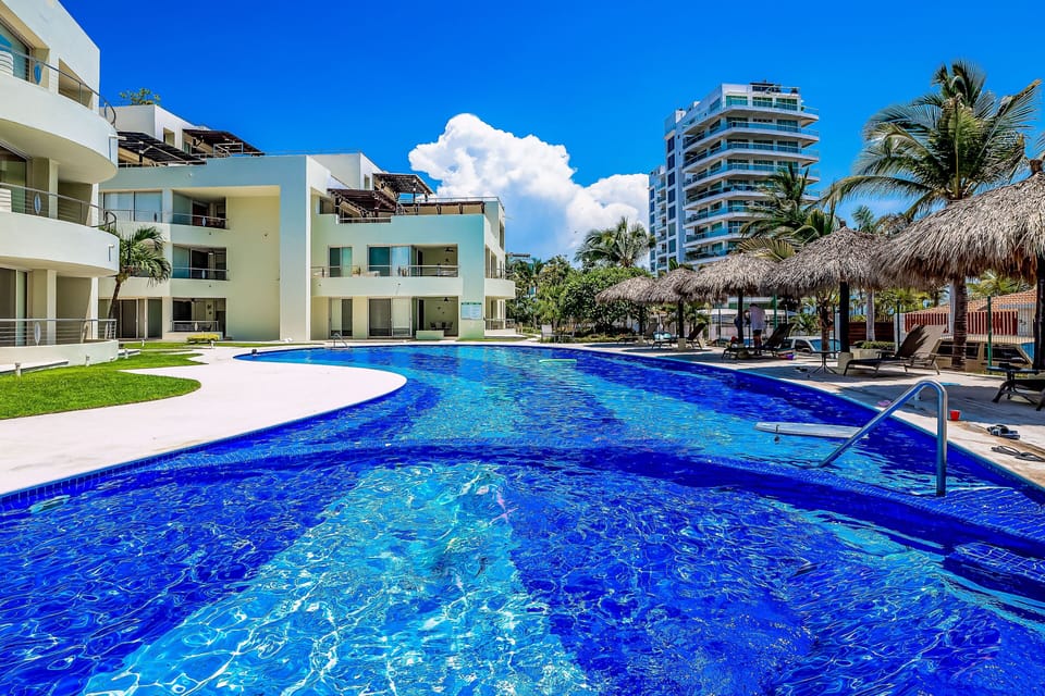 Enjoy the large resort-style pool surrounded by tropical scenery, lounge areas, and relaxing coastal vibes just steps from the beach.
