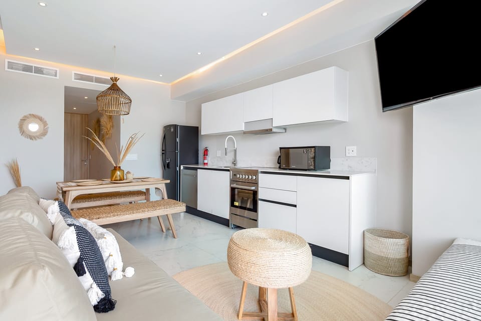Bright and fully equipped kitchen featuring modern appliances, sleek cabinetry, ample counter space, and everything needed to prepare meals with ease during your stay.