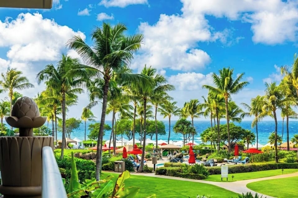 Stroll past lush lawns and palms with the ocean on the horizon, an easy preview of the Honua Kai beachfront setting. HKK-213