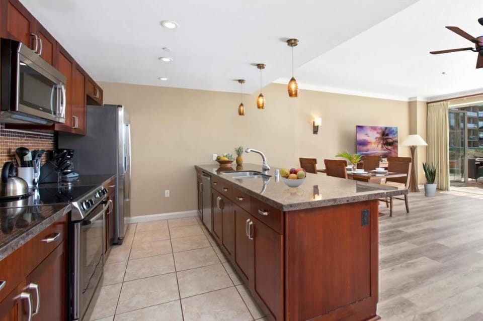 Open-concept kitchen flows into tropical dining and outdoor paradise views. HKK-229