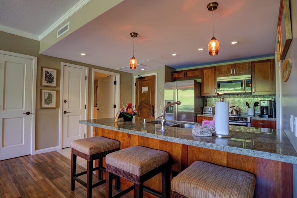 Warm wood cabinetry, granite island, and modern stainless steel appliances. HKK-242