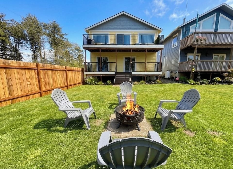 Large backyard featuring a wood fire pit and seating for outdoor gatherings.