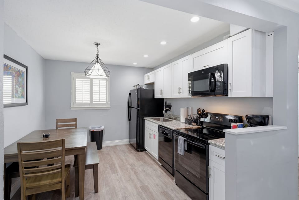 Fully equipped kitchen w/ black appliances & plenty of counter space to cook.
