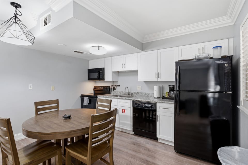 Fully equipped kitchen & dining area in Unit 202, ready for home-cooked meals.
