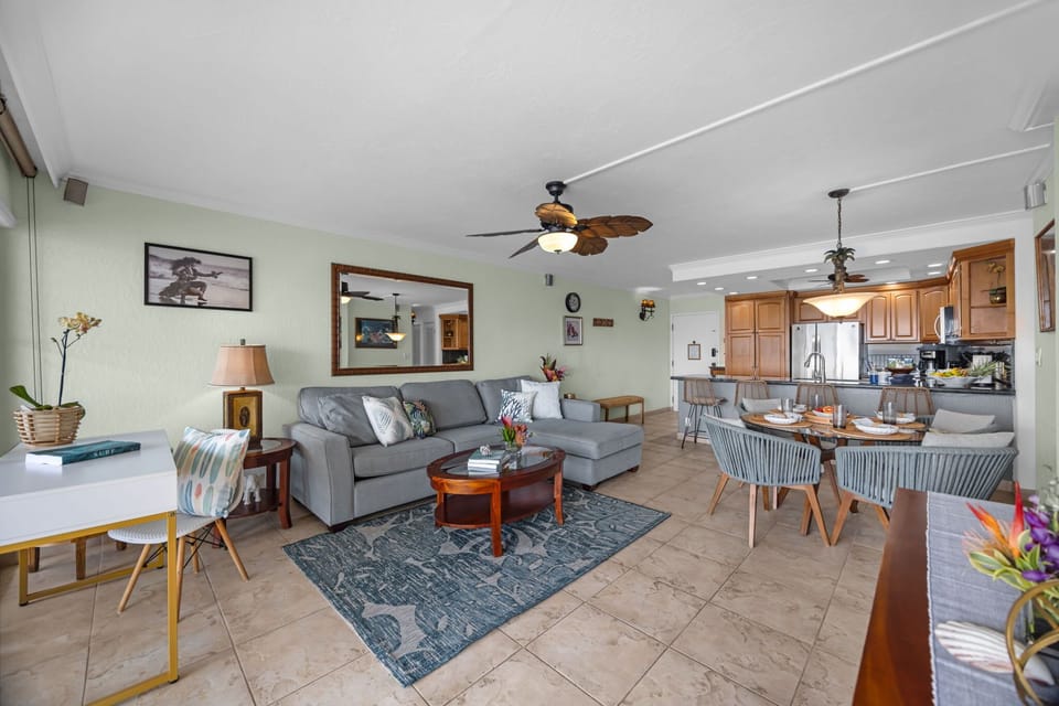 Spacious and inviting interior featuring a plush sectional sofa, dedicated workspace, and an elegant dining set for four.