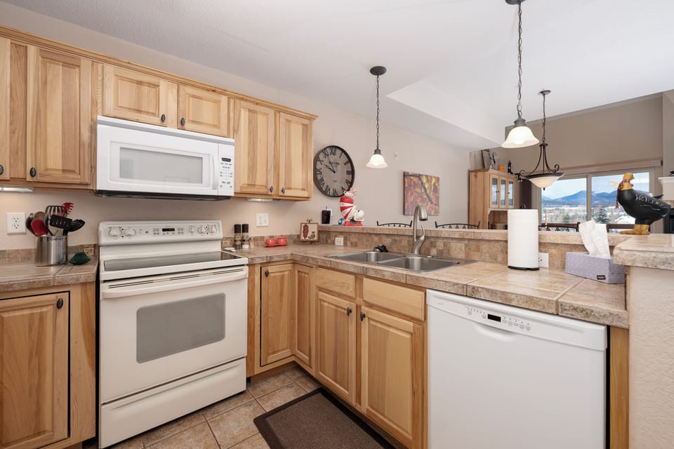 Your fully equipped kitchen invites culinary adventures with granite counters, modern appliances, and mountain views through the window.
