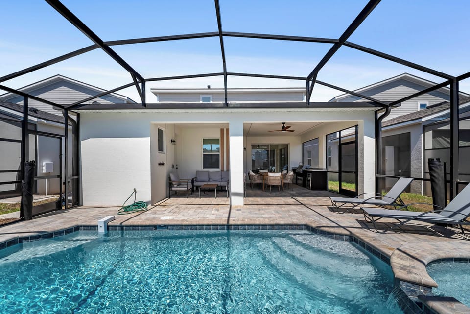 Discover your private paradise with a screened pool where sunlight sparkles on the water. Unwind on the comfy loungers or in the airy living area, just steps away, ideal for relaxing after a day of adventure.