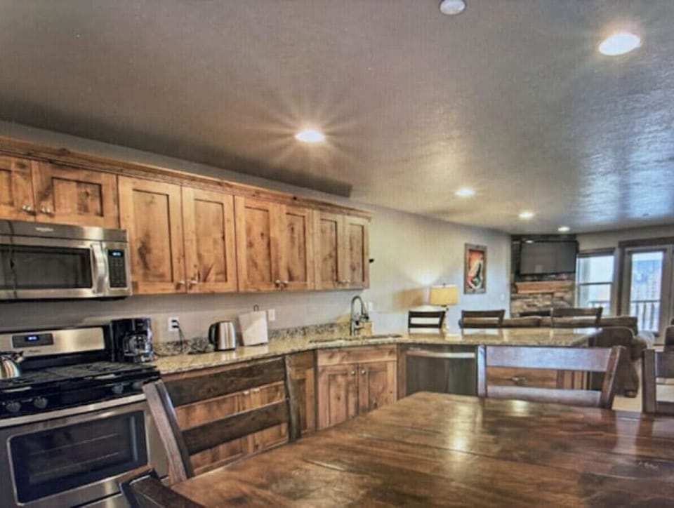 Kitchen | Granite Countertops | Bar Seating & Living Area View