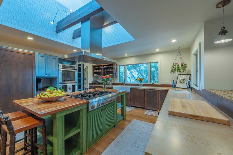 Your gourmet kitchen awaits with professional-grade appliances, butcher block prep areas, and stunning skylights that bathe your culinary adventures in natural light.