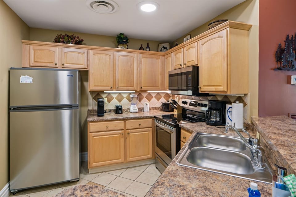 Your fully equipped kitchen features granite countertops, stainless steel appliances, and warm wood cabinets—perfect for preparing memorable vacation meals together.