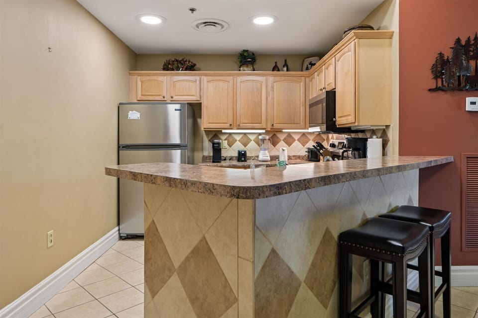 Your fully equipped kitchen awaits with granite countertops, stainless appliances, and a breakfast bar perfect for morning coffee.