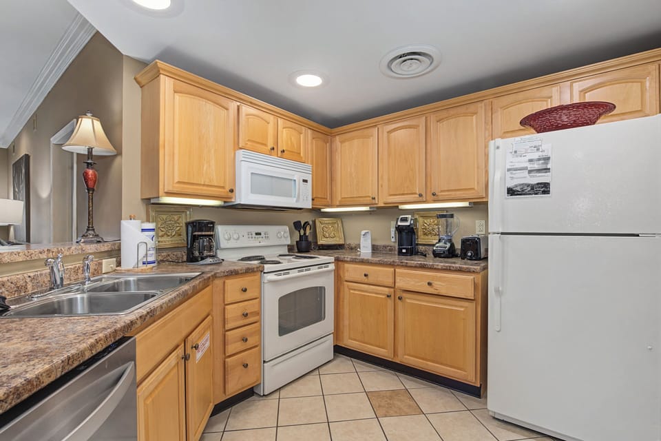Your fully equipped kitchen awaits with granite counters, warm wood cabinets, and everything needed for home-cooked meals during your stay.