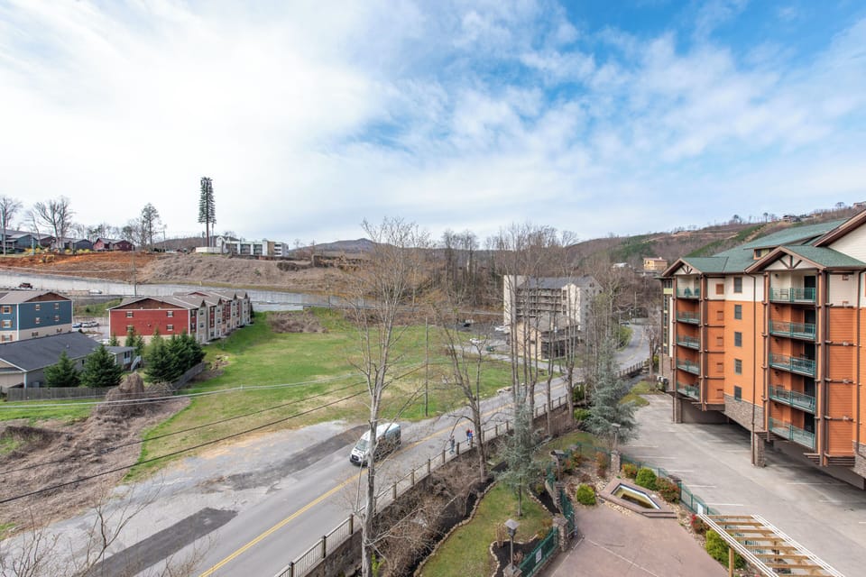 Scenic hillside community with modern apartment buildings and mountain backdrop near your vacation rental.
