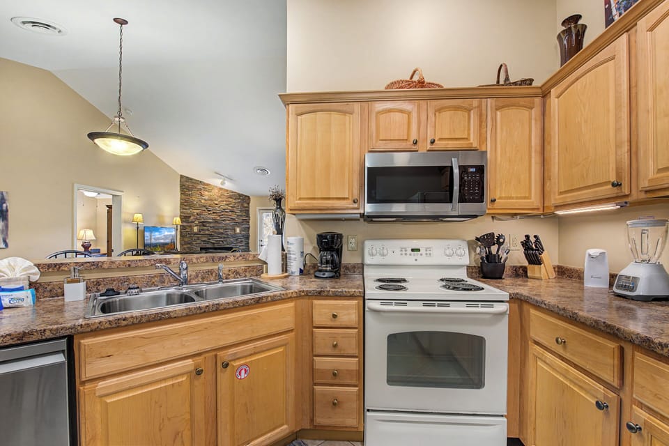 You'll love cooking in this fully equipped kitchen with warm wood cabinets, granite counters, and everything needed for memorable meals.