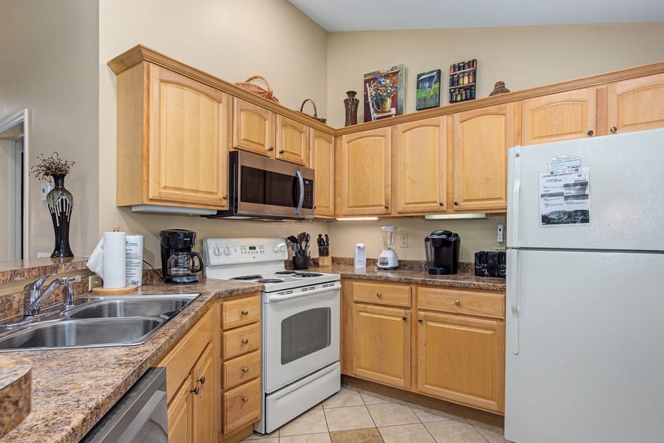 Your fully equipped kitchen awaits with warm wood cabinets, granite counters, and everything you need to create memorable meals during your stay.