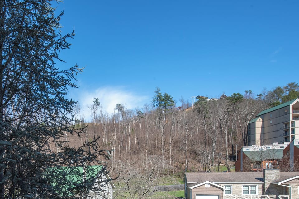 Mountain landscape surrounds the property with bare winter trees and clear blue skies creating a peaceful hillside setting.