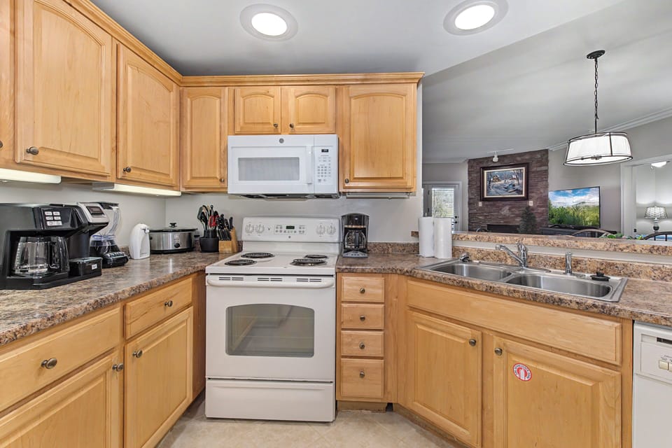 Your fully-equipped kitchen features warm wood cabinets and granite counters, perfect for preparing memorable meals during your stay.
