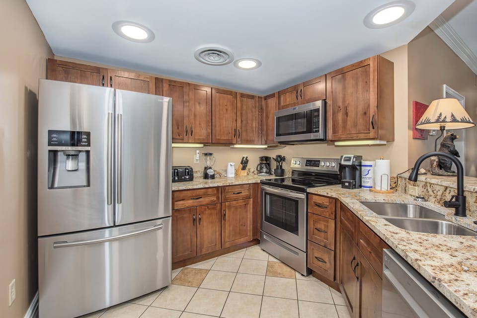 Your fully equipped kitchen features granite countertops, stainless steel appliances, and warm wood cabinets—everything you need to create memorable meals during your stay.