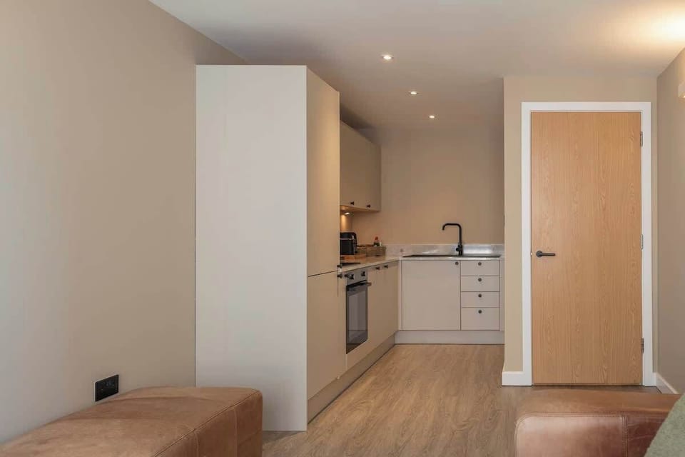 Stylish open-plan living space with a modern kitchen, sleek cabinetry, and warm wood finishes throughout.