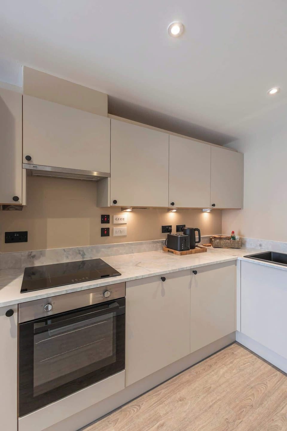 Stylish open-plan living space with a modern kitchen, sleek cabinetry, and warm wood finishes throughout.
