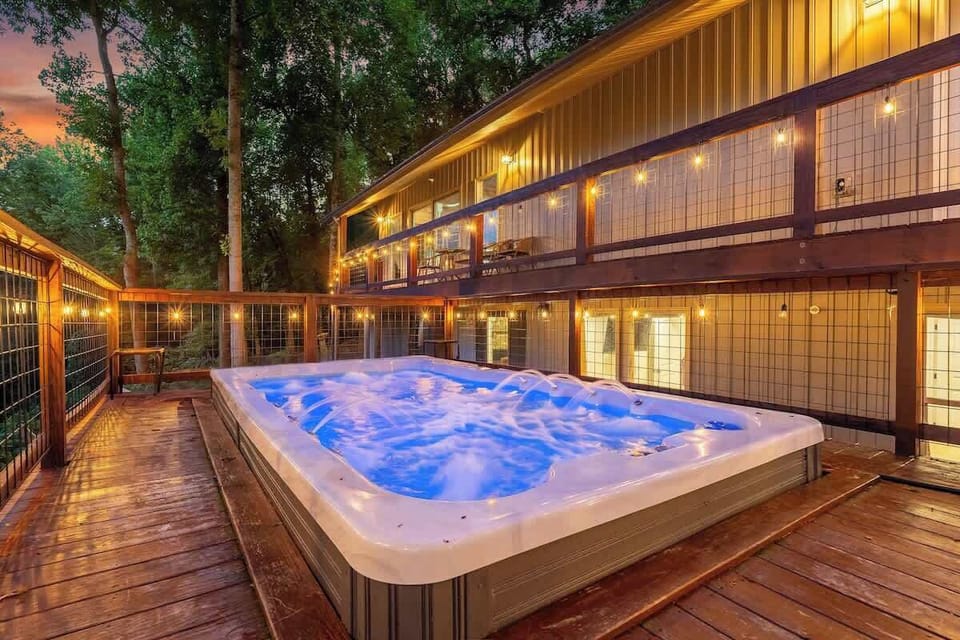 Private hot tub deck with string lights and a cozy wooded ambiance