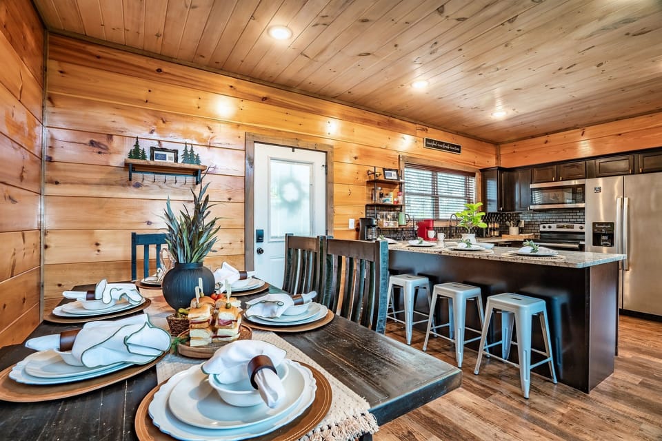 Dining area with seating for six and adjacent kitchen with breakfast bar.
