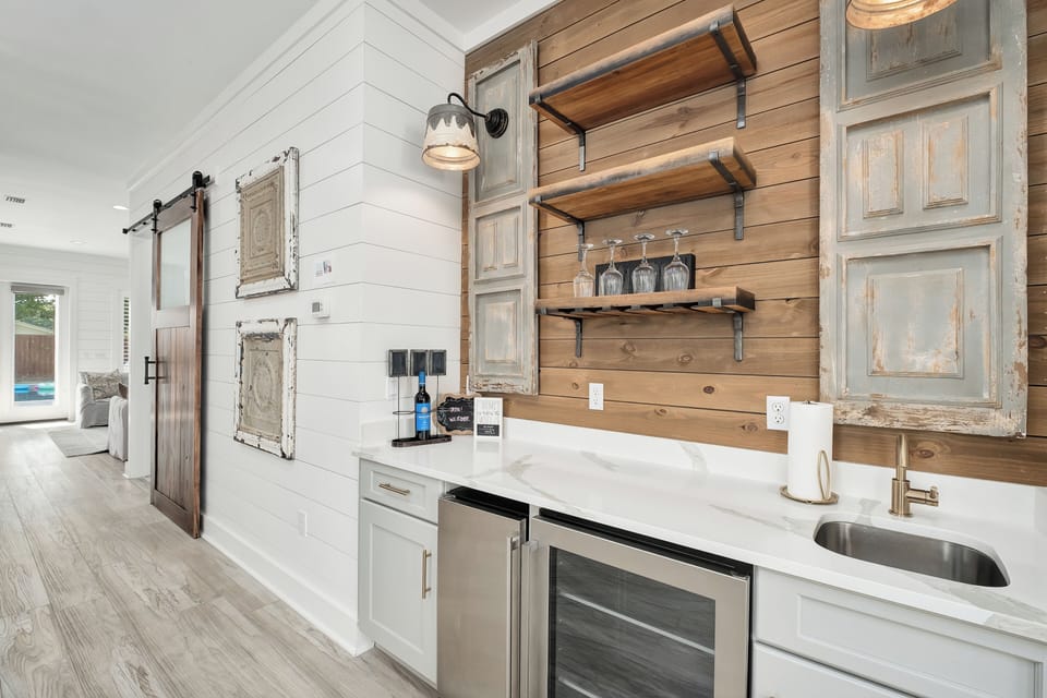 Your gourmet getaway awaits in this beautifully designed kitchen, where rustic charm meets modern elegance. Prepare meals with style at the gleaming countertops, and unwind with drinks from the sleek beverage fridge.