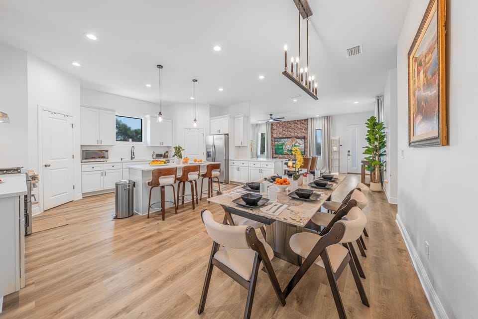 Open-concept kitchen and dining area featuring a large island, modern appliances, and ample seating for group meals.