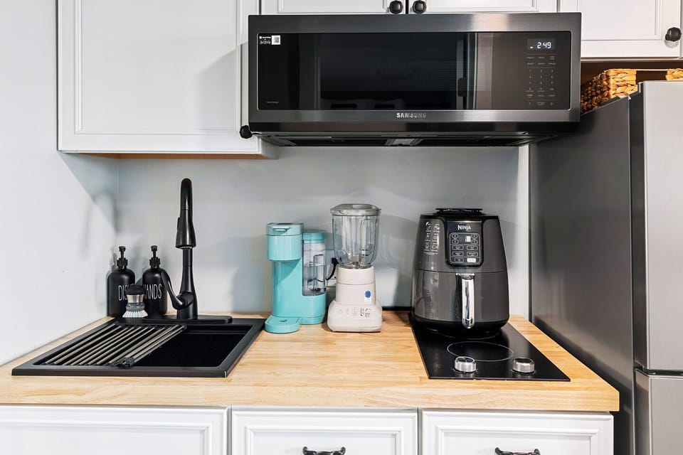 Microwave, toaster, blender, Keurig, air fryer, two burner stovetop, and fridge