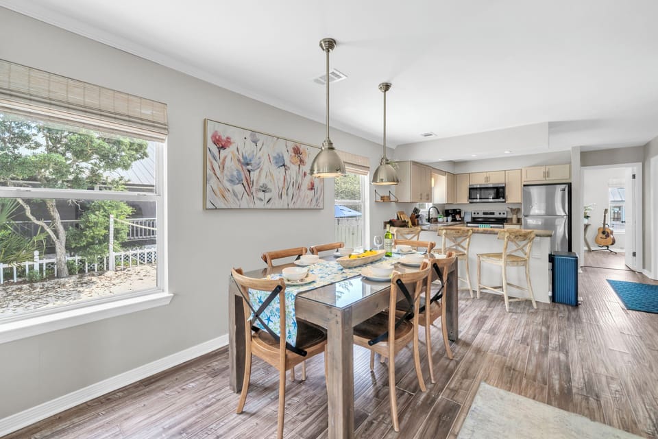Gather around this bright dining space where morning coffee flows into evening meals, all while soaking up garden views through oversized windows.