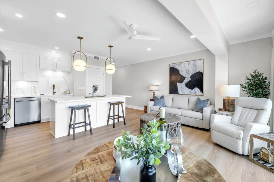 Relax in your bright, modern living space with comfortable seating and a fully equipped kitchen featuring a breakfast bar.