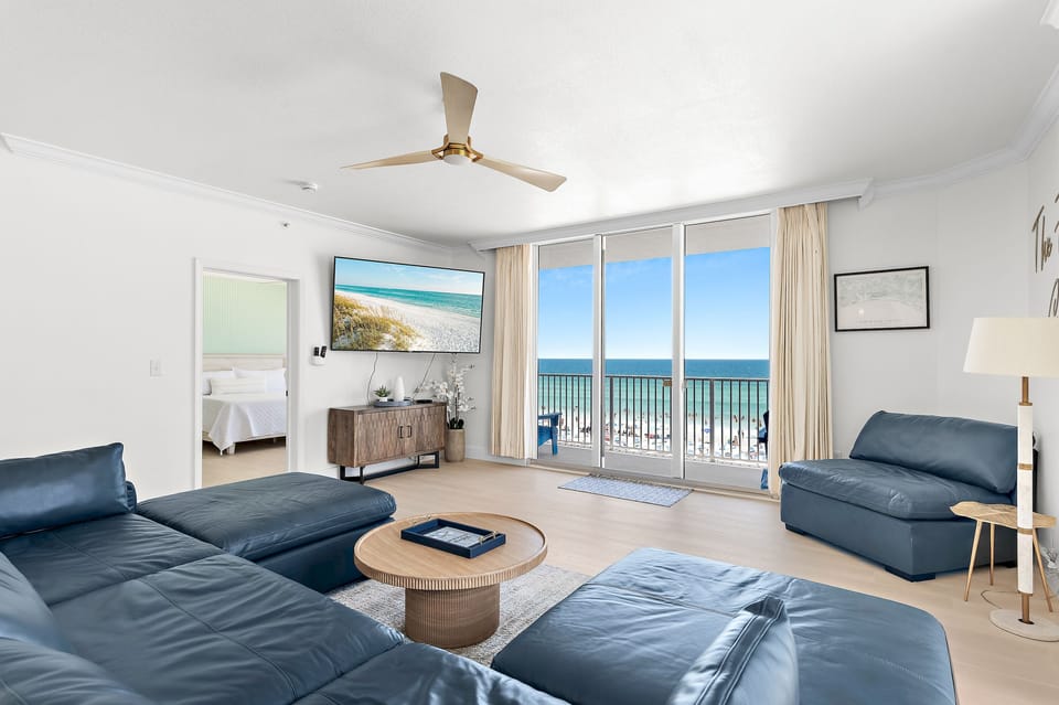 Large, Open Living Room with Gulf Views through Floor-to-Ceiling Sliding Doors, Patio Access, 75" Smart TV, and all New Leather Living Room Furniture