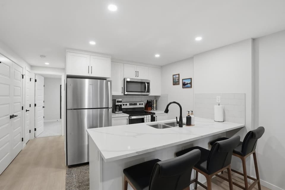 Modern kitchen with stainless steel appliances, seating for three at the kitchen island 