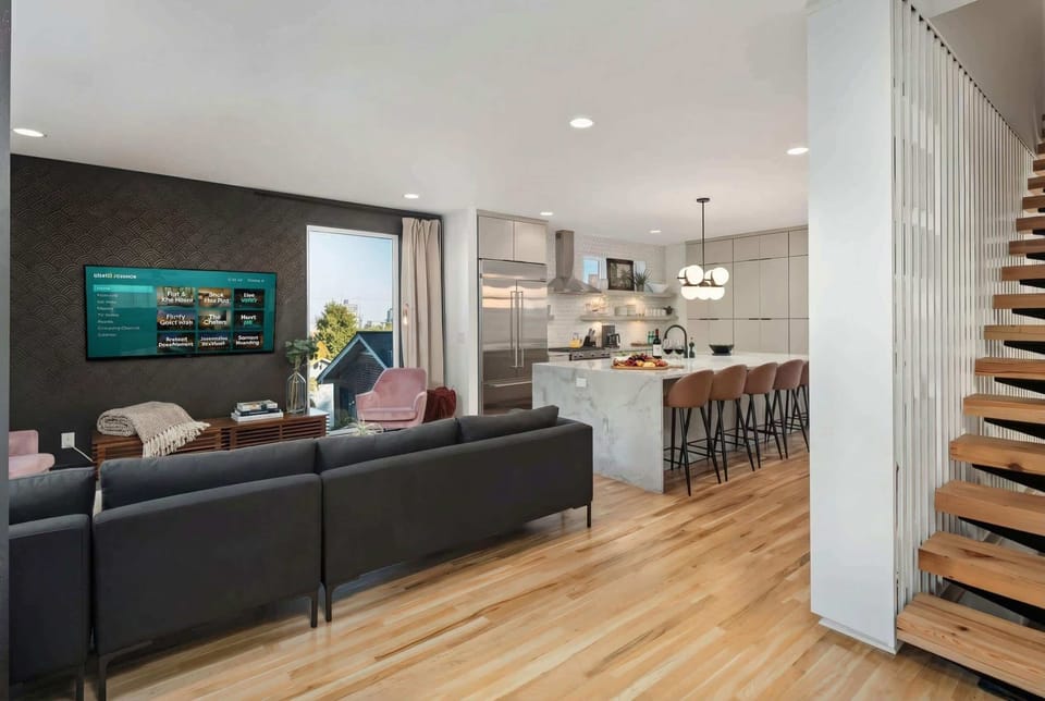 Open-concept kitchen and living room mean nobody's isolated. Sectional seating, island counter, and one big gathering space for all 12 of you