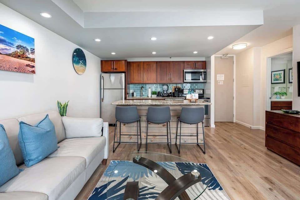 The kitchen and living room area offer a great space to hang out and talk stories. Both areas lookout over the lanai (balcony) into the panoramic ocean view.