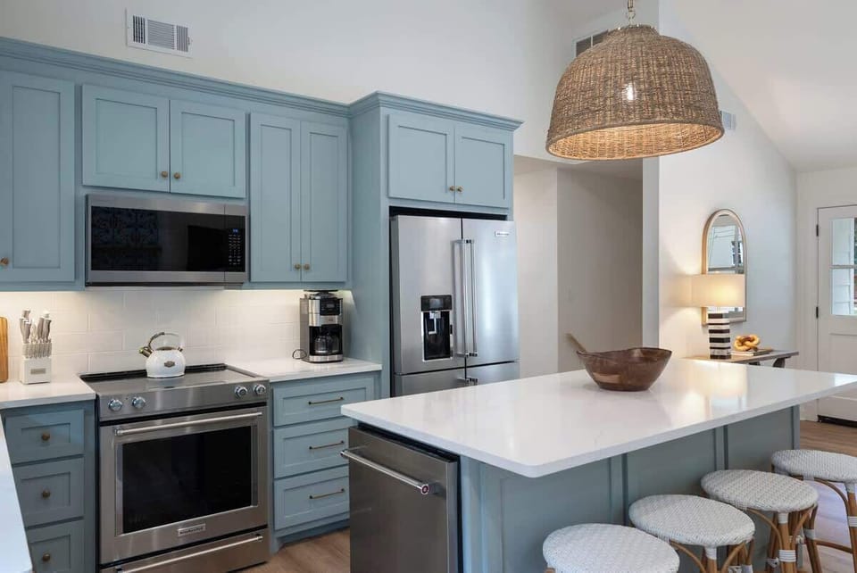 Modern kitchen w/ sleek cabinets, island seating & stylish lighting