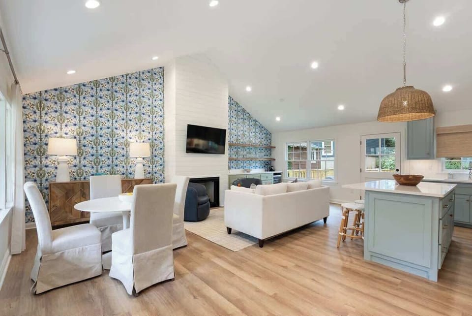 Open living space flowing into kitchen w/ bright finishes & seating