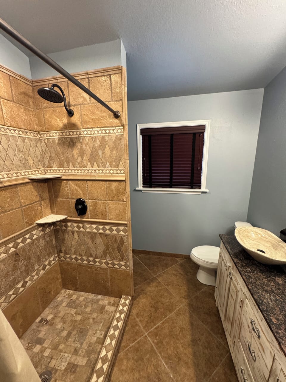 Spa-like duel head walk-in shower, vessel sink, and rustic vanity.