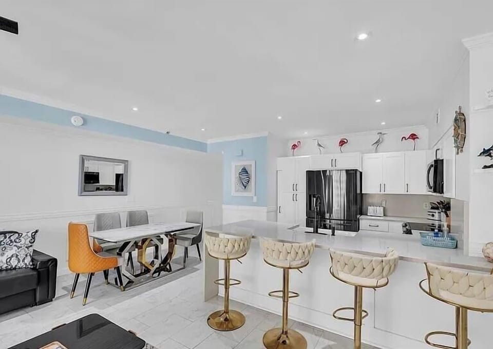 Kitchen and dining areas with breakfast bar seating on kitchen counter