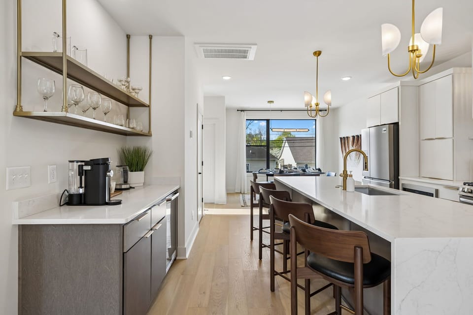 Kitchen: A spacious kitchen featuring a large island, bar stools, and pendant lights above.