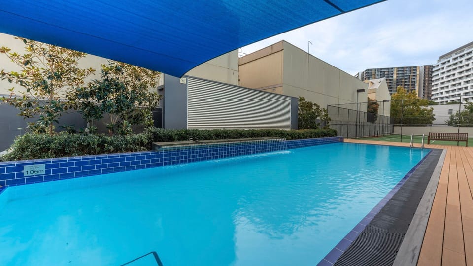 Outdoor pool with shaded area, perfect for relaxing or cooling off on warmer days