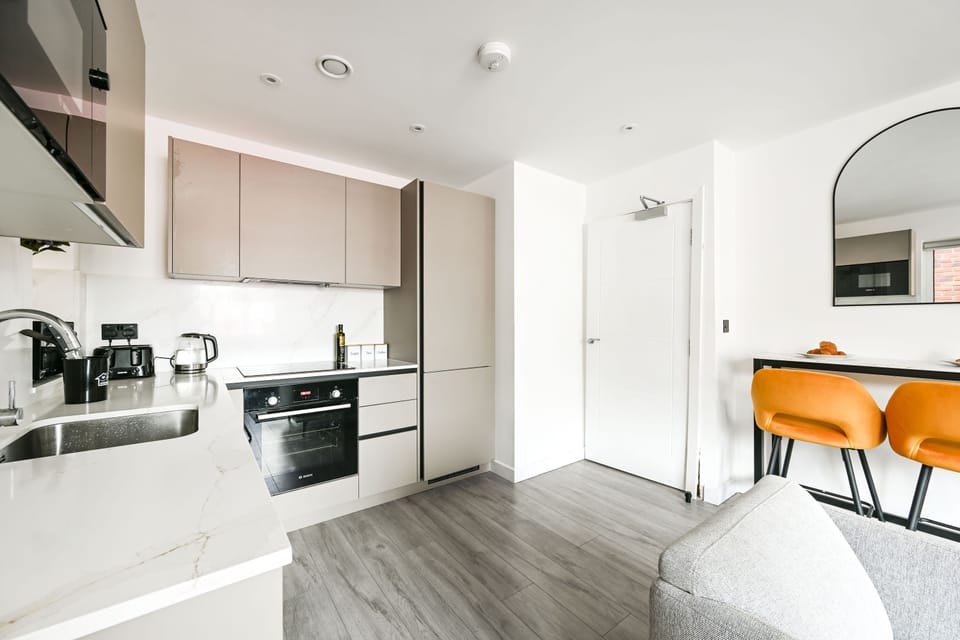 Kitchen seen from the lounge, with the hob, extractor and oven along one wall