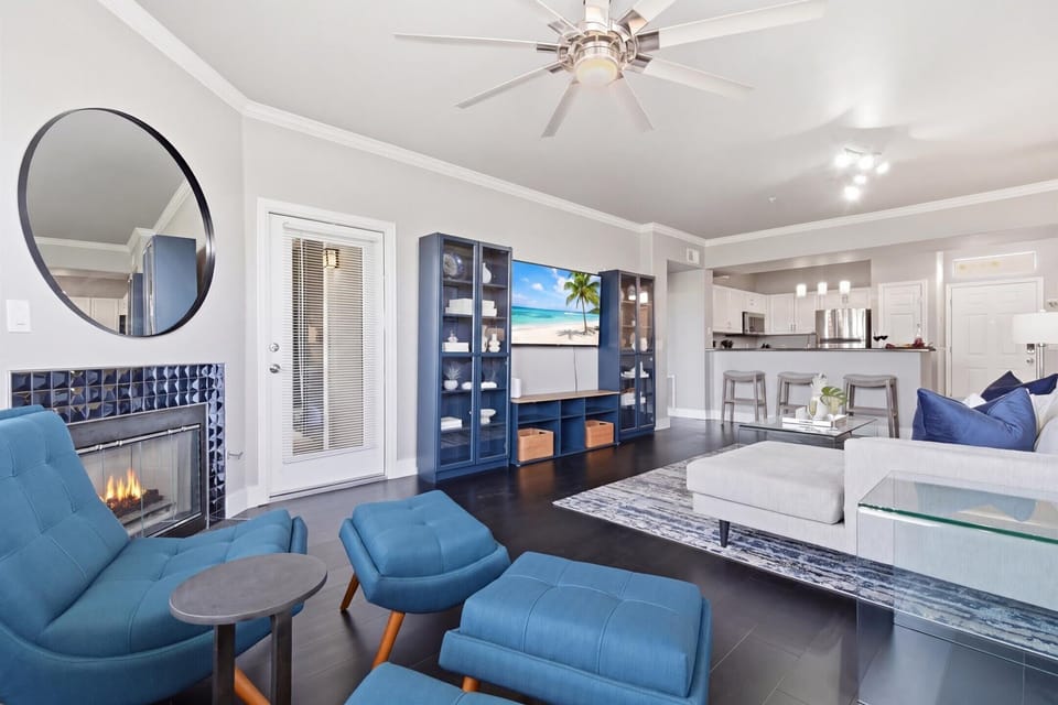 Bright and open living area featuring cozy furnishings, a Smart TV, fireplace, and access to the private balcony.
