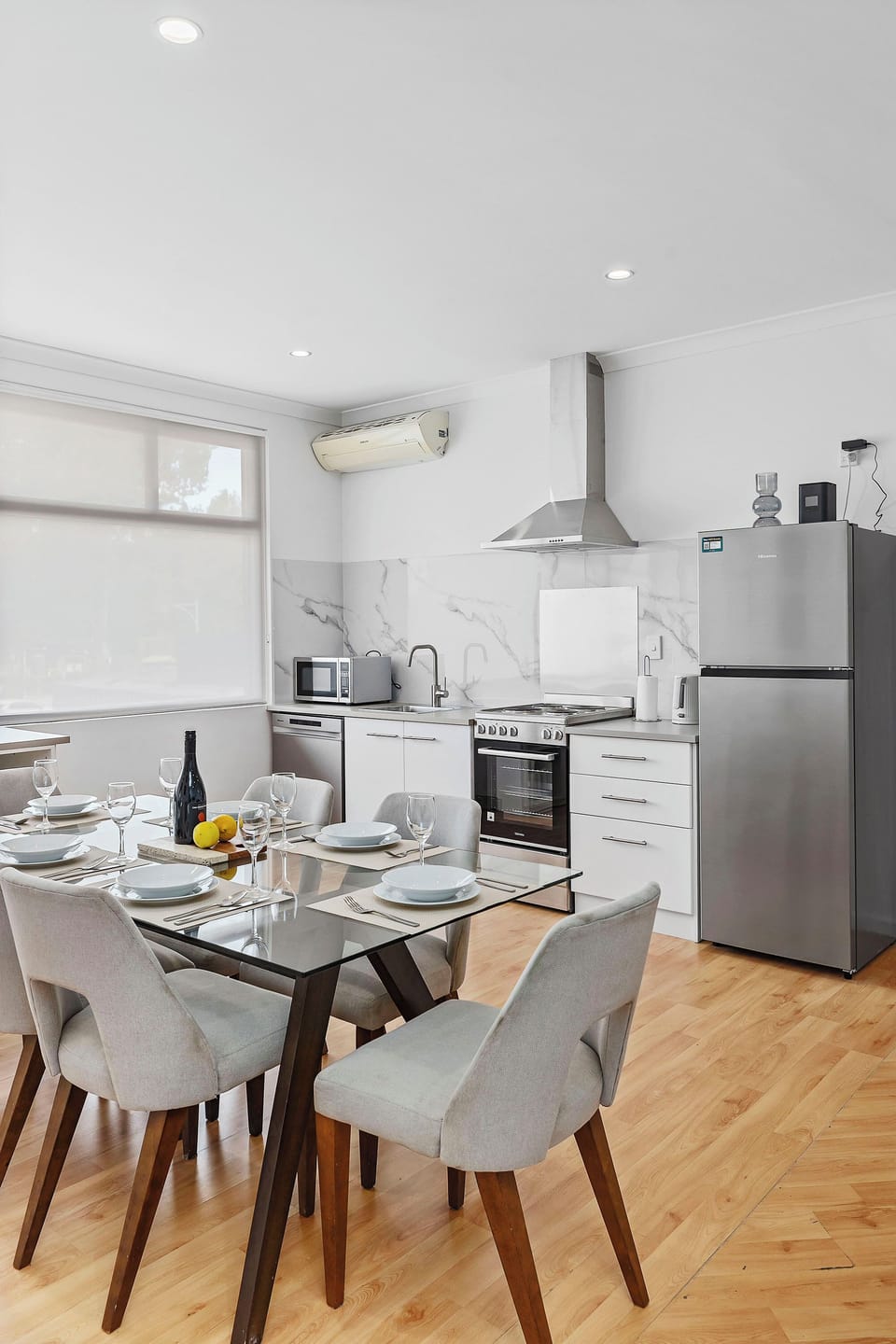 Light-filled dining area and fully-equipped, modern kitchen with appliances.