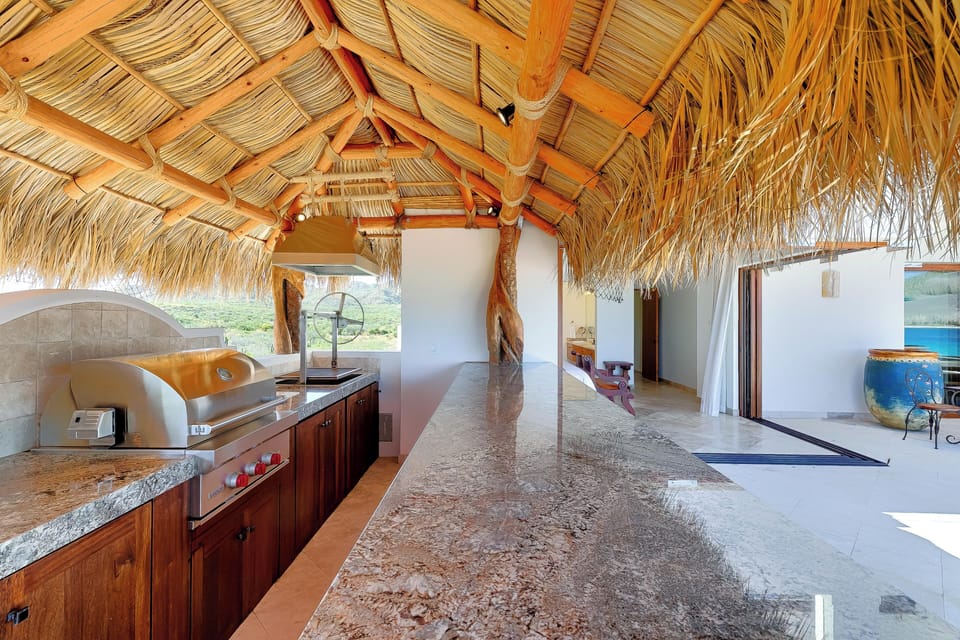 Your private palapa kitchen features granite counters, premium appliances, and tropical charm with authentic thatched roofing overhead.