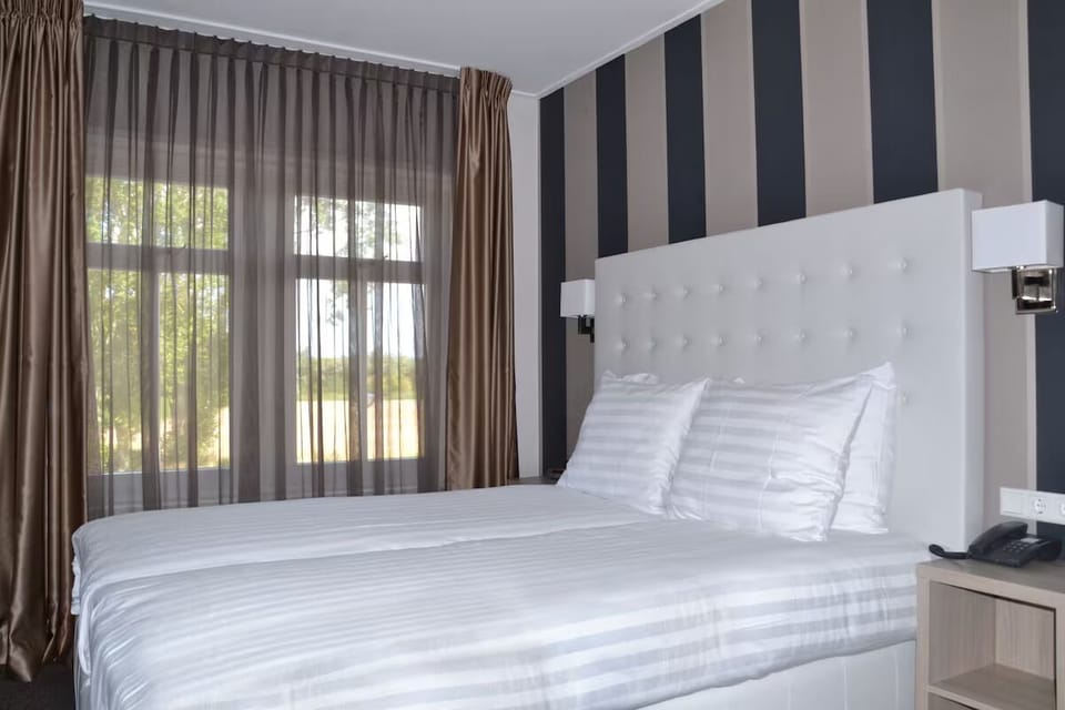 Unwind in crisp linens beside soothing daylight and views.
