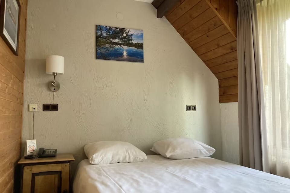 Drift off comfortably under soft pillows and warm wood accents.